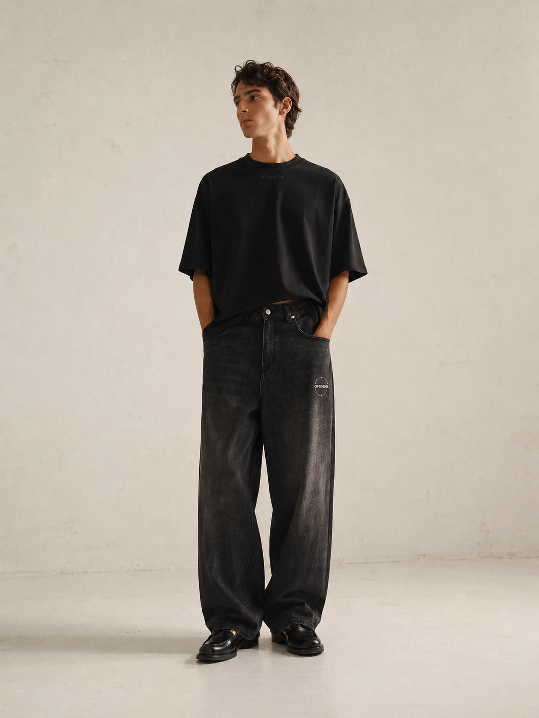 OPTIMISM. Summertime Closing — black tee with washed wide-leg denim, studio